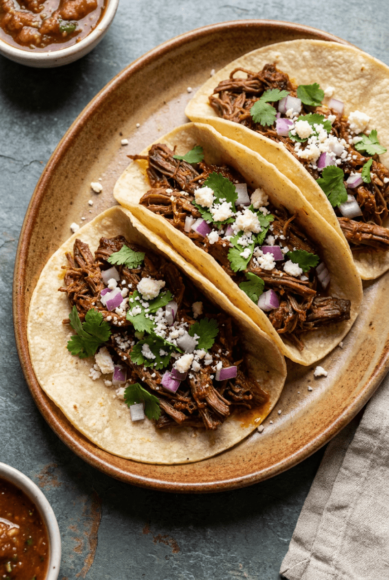 smoky chipotle shredded beef tacos recipe - Smoky Chipotle Shredded Beef Tacos served in a white bowl overhead view